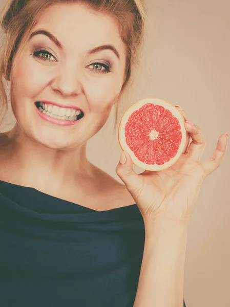 Feliz mujer sonriente sosteniendo pomelo rojo — Foto de Stock