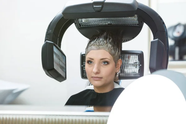 Mujer en peluquería, secando el cabello bajo la máquina —  Fotos de Stock