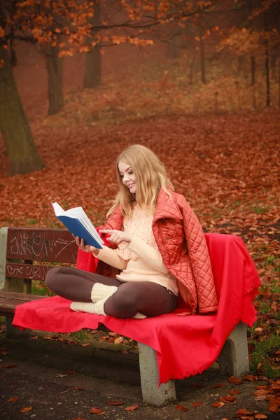 Chica rubia leyendo libro en el paisaje de otoño — Foto de Stock