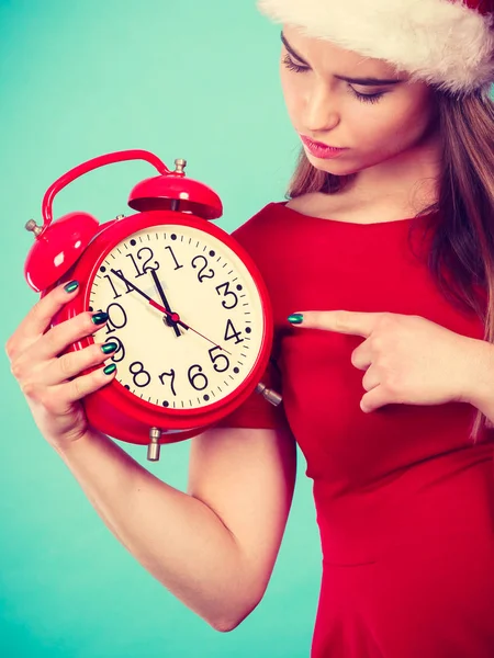 Feliz mulher vestindo Papai Noel traje segurando relógio — Fotografia de Stock