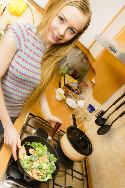 Mujer cocinando saltee verduras congeladas en la sartén — Foto de Stock