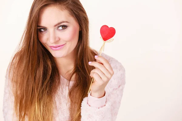 Flirty woman holding red wooden heart on stick — Stock Photo, Image