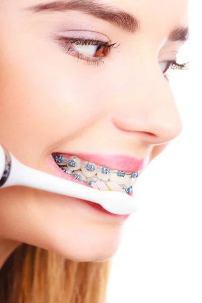 Женщина чистит зубы скобками с помощью щетки — стоковое фото