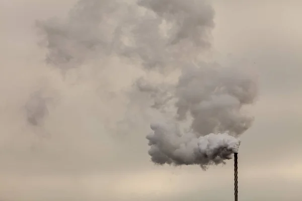 Humo de chimenea en el cielo nublado oscuro — Foto de Stock