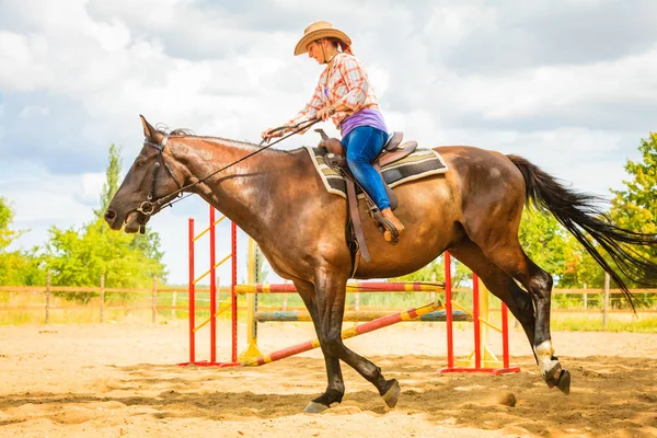 Cowgirl in westerse hoed doen paard springen — Stockfoto