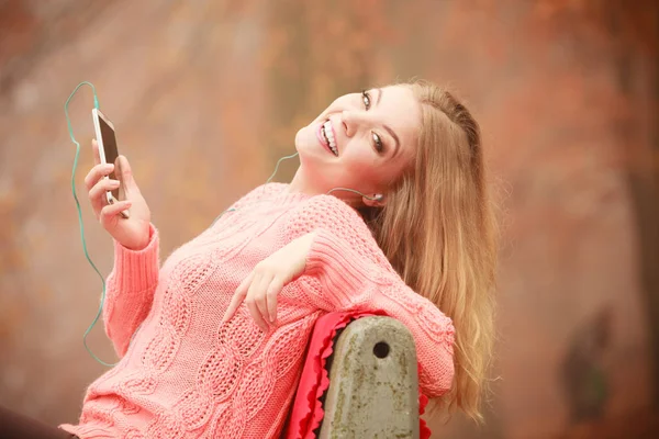 Chica escuchando música en el parque de otoño — Foto de Stock