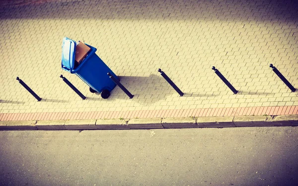 Blue trash can on street pavement — Stock Photo, Image