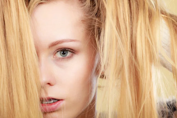 Blonde woman holding her long tangled hair — Stock Photo, Image