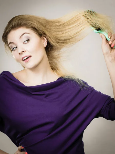 Woman brushing her long hair with brush — Stock Photo, Image