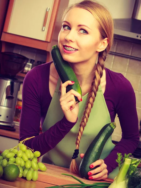 Mulher na cozinha detém abobrinha vegetal — Fotografia de Stock