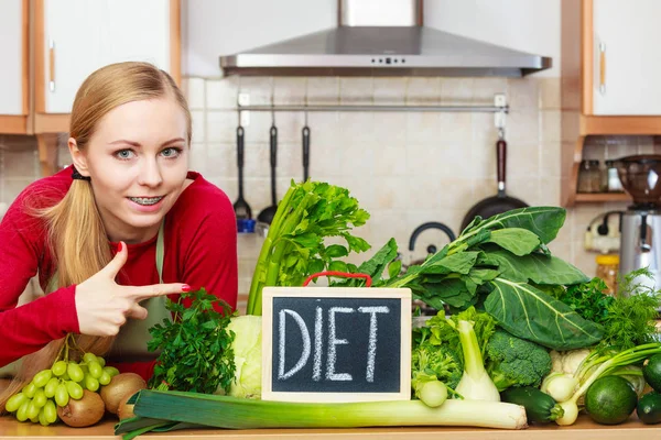 Femme dans la cuisine ayant des légumes de régime vert — Photo
