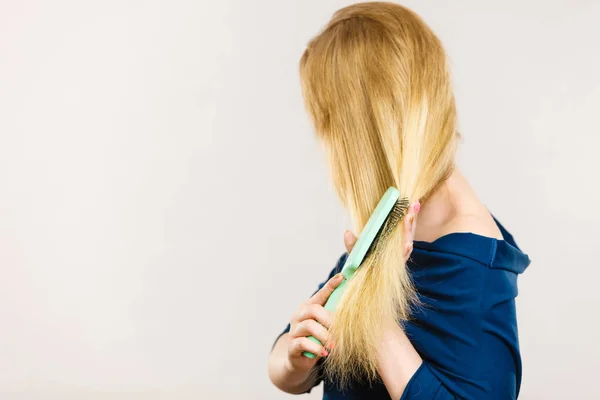 女性は、彼女の長い髪をブラシでブラッシング — ストック写真