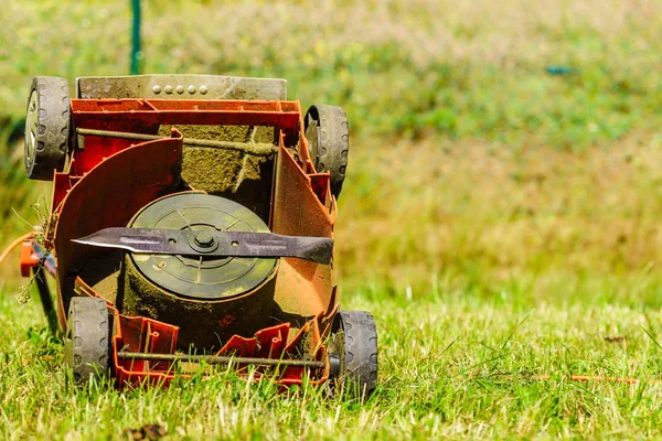 Gebroken oude grasmaaier in gras van de achtertuin — Stockfoto