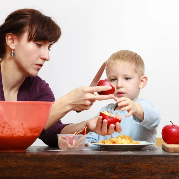 Kleine jongen en moeder peeling appels met mes — Stockfoto