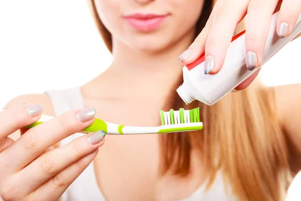 Frau trägt Zahnpasta auf ihre Zahnbürste auf — Stockfoto