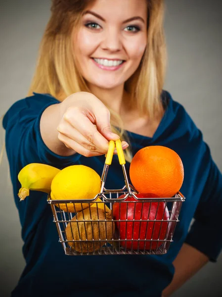 Mujer sosteniendo cesta con frutas en el interior —  Fotos de Stock