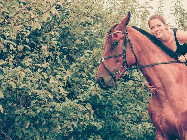 Jovem mulher abraçando e sentado no cavalo — Fotografia de Stock