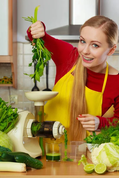 Woman in kitchen making vegetable smoothie juice — Stock Photo, Image