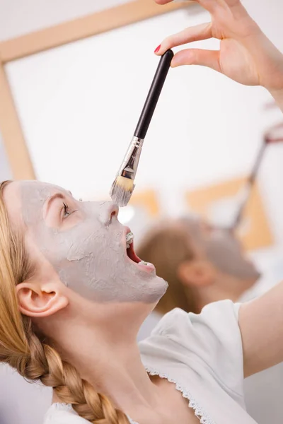 Woman applying with brush clay mud mask to her face — Stock Photo, Image