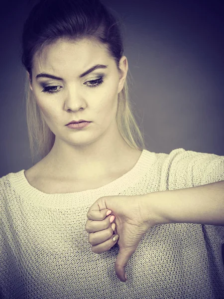 Mujer triste mostrando el pulgar hacia abajo gesto — Foto de Stock