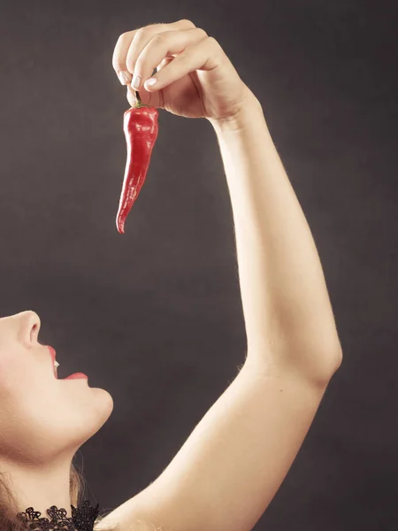 Woman wearing lingerie holding chilli pepper — Stock Photo, Image