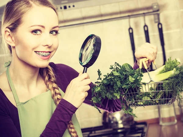 Mujer mirando lupa a las verduras — Foto de Stock