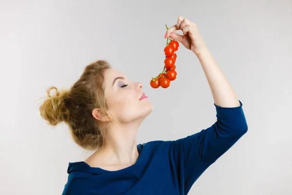Mulher segurando tomates cereja frescos — Fotografia de Stock