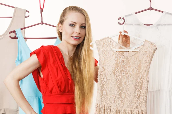 Kvinnan i butiken eller garderob plocka klänning — Stockfoto