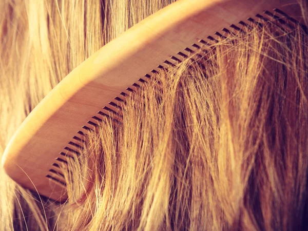 Cabello castaño liso con peine de madera — Foto de Stock