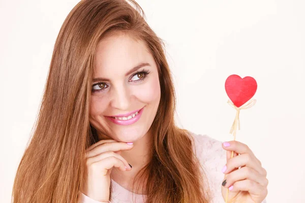 Flirty woman holding red wooden heart on stick — Stock Photo, Image