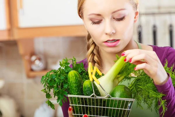 Женщина на кухне с овощами держит корзину — стоковое фото