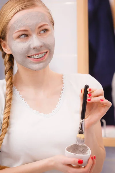 Mulher aplicando com escova de barro máscara de lama para o rosto — Fotografia de Stock
