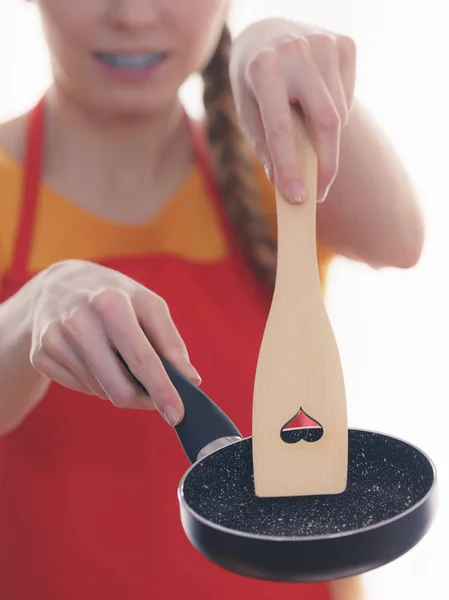 Woman hand holding cooking pan and spatula — Stock Photo, Image