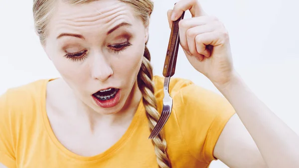Mujer conmocionada sosteniendo tenedor — Foto de Stock