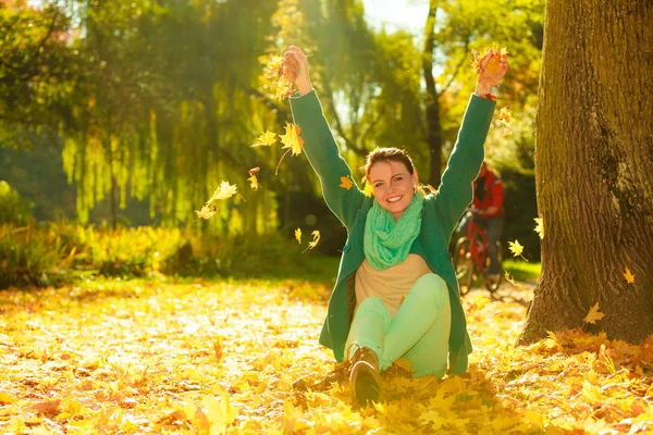 Šťastná žena, házení na podzim listy v parku — Stock fotografie