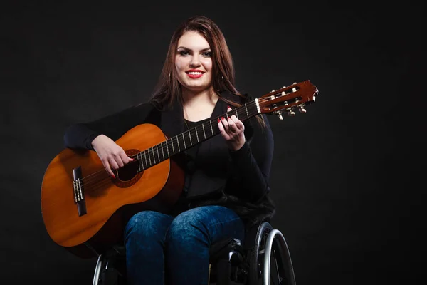 Женщина-инвалид на инвалидной коляске с гитарой — стоковое фото
