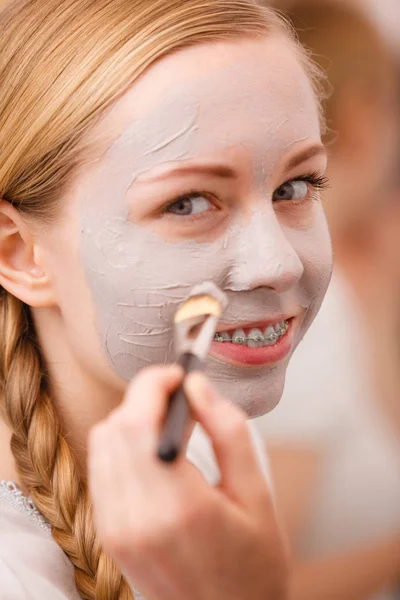Mutlu genç kadın yüz çamur maskesi uygulama — Stok fotoğraf