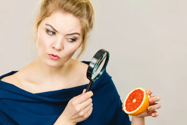 Mujer sosteniendo pomelo de aspecto de lupa — Foto de Stock