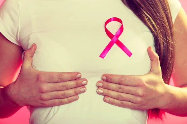 Rosafarbenes Band auf der Brust einer Frau zur Unterstützung von Brustkrebs — Stockfoto