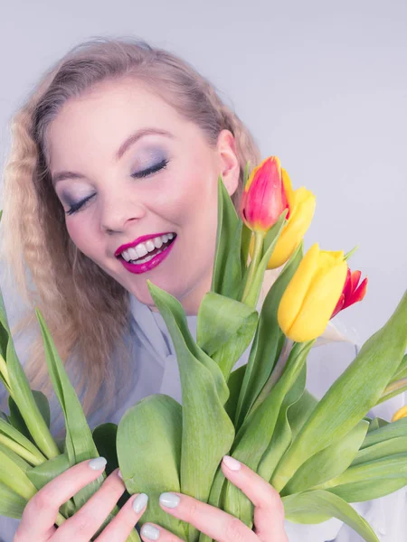 Pretty woman s bandou červené žluté tulipány — Stock fotografie