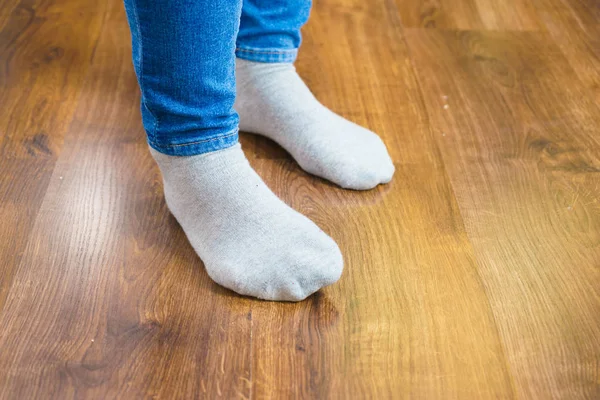 Woman feet wearing socks and jeans trousers