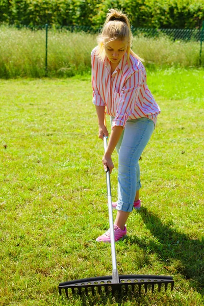 Mujer usando rastrillo para limpiar el jardín —  Fotos de Stock