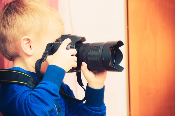 Dziecko bawi się duży profesjonalny aparat cyfrowy — Zdjęcie stockowe