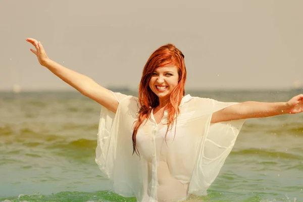 Mulher ruiva brincando na água durante o verão — Fotografia de Stock