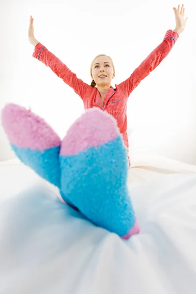 Žena v pyžamu na sobě furry teplé ponožky — Stock fotografie