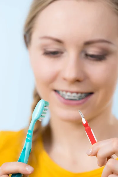 Mulher sorrindo dentes de limpeza com aparelho — Fotografia de Stock