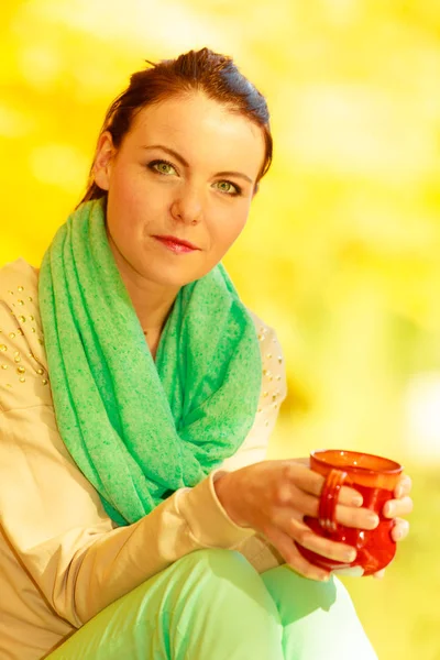 Woman relaxing in park drinking drink from mug — Stock Photo, Image