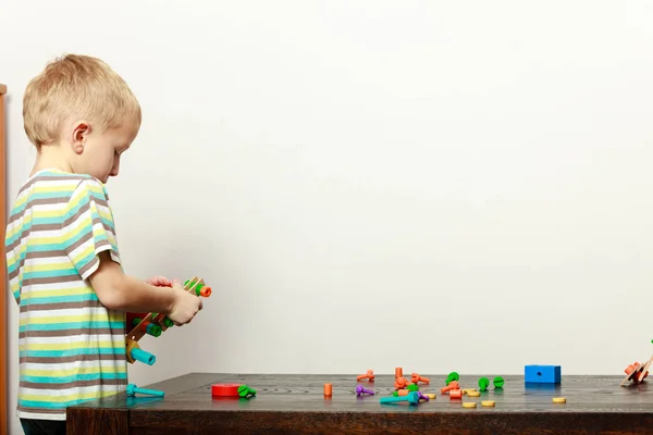 Piccolo ragazzo che gioca con i giocattoli divertendosi — Foto Stock