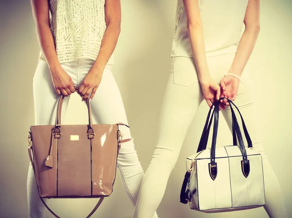 Two slim women in with leather bags handbags. — Stock Photo, Image