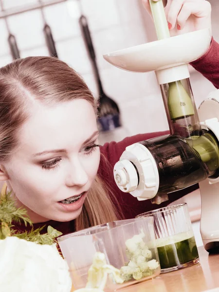 Mulher na cozinha fazendo suco de smoothie vegetal — Fotografia de Stock